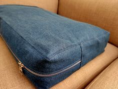 a blue denim pillow sitting on top of a couch