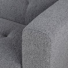 the back end of a grey couch with buttons on it's armrests