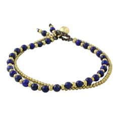 Thailand's Tiraphan Hasub orchestrates a dazzling harmony of colors with the design of this bracelet. She crafts the bracelet by hand combining lapis lazuli and glistening brass beads. The bracelet has a loop and hollow brass bell closure. Adjustable Spiritual Wrap Bracelet With Faceted Beads, Adjustable Bangle With Faceted Beads, Adjustable Spiritual Friendship Bracelets With Faceted Beads, Adjustable Faceted Beads Bracelet For Friendship, Adjustable Beaded Bracelet With Polished Beads, Adjustable Spiritual Bracelet With Polished Beads, Harmony Of Colors, Casual Bracelets, Brass Bell