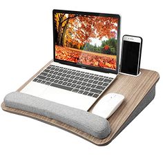 an open laptop computer sitting on top of a wooden desk next to a mouse and cell phone