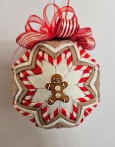 a christmas ornament with a gingerbread man hanging from it's side