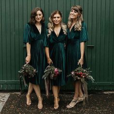 three women in green dresses standing next to each other