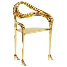 a chair made out of gold colored material with legs and arms that are bent to the side