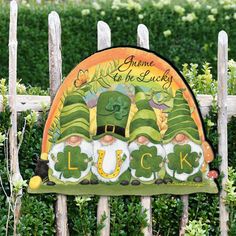 a wooden fence with a sign that says luck and three lepreti hats on it