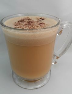 a glass mug filled with liquid sitting on top of a table