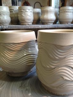 two white vases sitting next to each other on a table