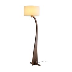 a floor lamp with a white shade on it's side and a brown base