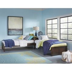 a bedroom with two twin beds, blue walls and yellow accents on the bedding