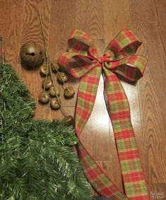 a christmas tree with a red and green plaid bow on it's side next to other holiday decorations