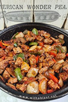 a pan filled with meat and vegetables on top of a table next to a sign that says african wonder pea