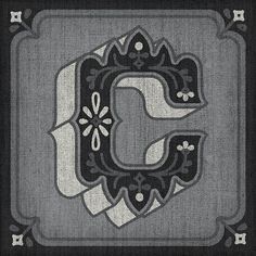 the letter e is made up of black and white fabric with an ornate design on it