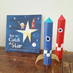 two cardboard rockets sitting on top of a wooden table next to a sign that says how to catch a star