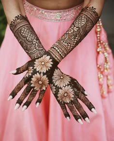 two hands with henna designs on them