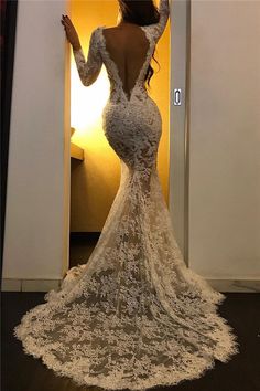 a woman in a white wedding dress standing in front of a doorway with her arms outstretched