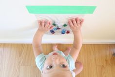 a young child is playing with plastic beads on the ceiling above his head and hands