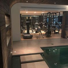 an indoor gym with a swimming pool and exercise equipment