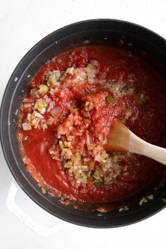 a pot filled with red sauce and chopped vegetables