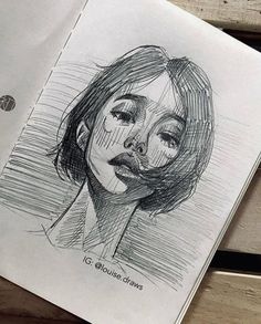 a pencil drawing of a woman's face on top of a piece of paper