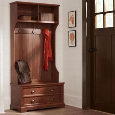 a wooden bench sitting next to a door with a purse on it's chest