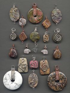 many different types of pendants are displayed on a gray surface, including one in the middle