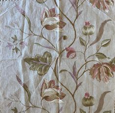 an old piece of cloth with flowers and leaves on it, sitting on a table