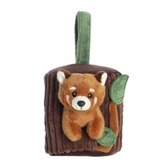 a brown teddy bear hanging from a green cord with leaves on it's back