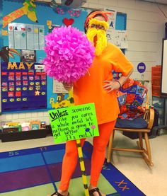 a person dressed in an orange outfit holding flowers and a sign that says unless someone who you are not supposed to put on