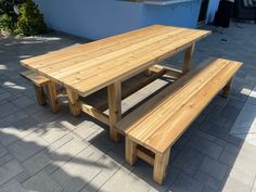 a wooden table and two benches on a patio