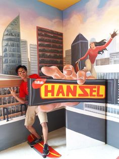 a man standing in front of a wall mural with a sign that says hansel