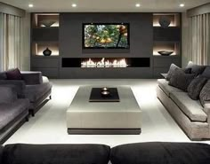 a large living room with couches and a television mounted on the wall in front of a fireplace