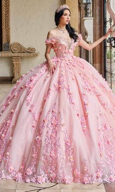 a woman in a pink ball gown with flowers on the skirt and headpieces