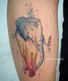 an elephant tattoo on the leg with watercolor paint and stars around it's head