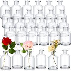 several vases with flowers in them and one red rose on the bottom, surrounded by smaller ones