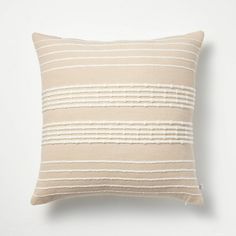 a beige and white striped pillow sitting on top of a wall