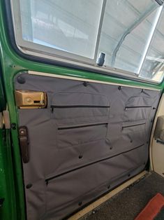 the inside of a vehicle with its door open and window partially covered by a tarp