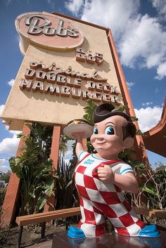 a statue of mickey mouse in front of a sign