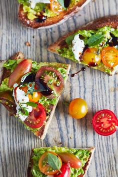 several slices of bread with tomatoes, lettuce and other toppings on them