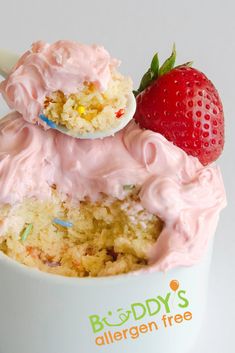 there is a cupcake with pink frosting and strawberries on top in the cup