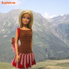 a crocheted doll is standing in the mountains