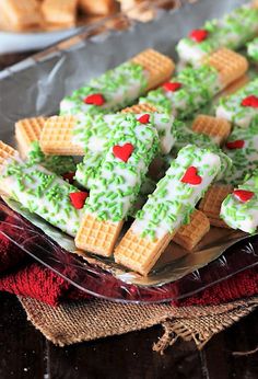 some green and white waffles with sprinkles are on a glass plate