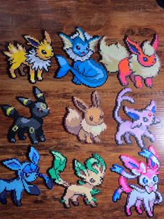 some pixelated pokemon stickers sitting on top of a wooden table