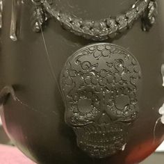 a black vase with a skull on it