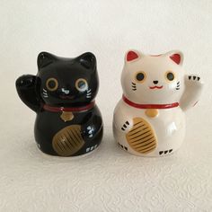 two black and white ceramic cats sitting next to each other