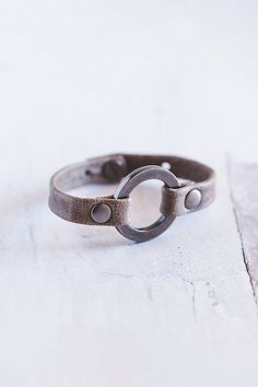 Designed to remind us that we all need to reconnect and ground to nature, our Grounding bracelet is handcrafted from the softest lamb leather and features a chunky antique silver ring with matching rivets. **Contents** * Lambskin leather, zinc alloy hardware * Button clasp closure * Handmade **Care/Import** * Made in the USA **Dimensions** * Adjustable to fit wrist sizes 6.5”-8” | Giving Bracelets Antique Silver Grounding Leather Bracelet at Free People in Grey Antique Silver Rings, Boho Clothing, Lambskin Leather, Rivets, Womens Jewelry Bracelets, Zinc Alloy, Antique Silver, Leather Bracelet, Silver Ring