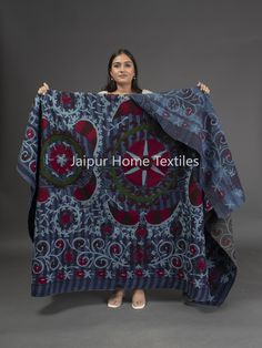 a woman holding up a blue and red blanket