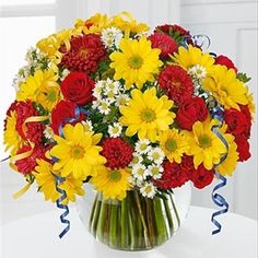 a vase filled with yellow and red flowers