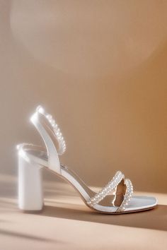 a pair of white shoes with pearls on them