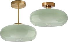 two light green glass pendants hanging from a gold ceiling fixture with metal fittings