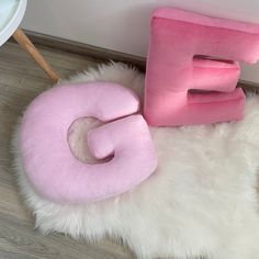 a pink and white cat bed sitting on top of a rug next to a wall