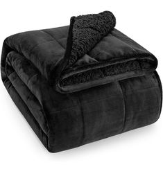 a black blanket is folded on top of each other with a fuzzy thrower in the middle